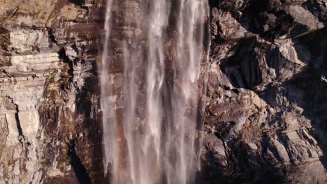 Aerial-drone-footage-raising-down-and-pushing-out-at-Fallbach,-a-stunning-waterfall-in-Grindelwald-in-Switzerland