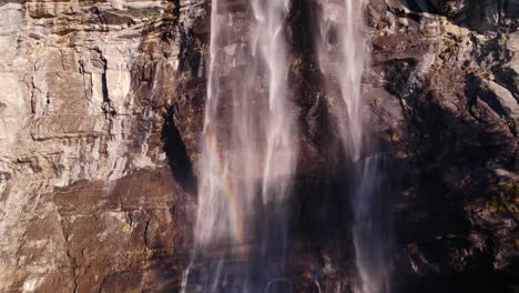 Drohnenaufnahmen-Aus-Der-Luft,-Die-Auf-Einen-Beeindruckenden-Wasserfall-Mit-Farbenfrohen-Lichtreflexen-In-Grindelwald-In-Der-Schweiz-Drängen