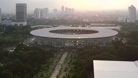 GBK-Stadium-Park-Skyline-En-El-Centro-De-Yakarta-Indonesia-Al-Atardecer,-Antena