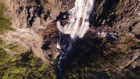 Aerial-drone-footage-raising-up-top-down-view-of-a-dreamy-waterfall-in-Grindelwald-in-the-Swiss-Alps