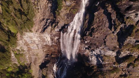 Aerial-drone-footage-orbiting-clockwise-top-down-views-of-a-dreamy-waterfall-in-Grindelwald-in-the-Swiss-Alps