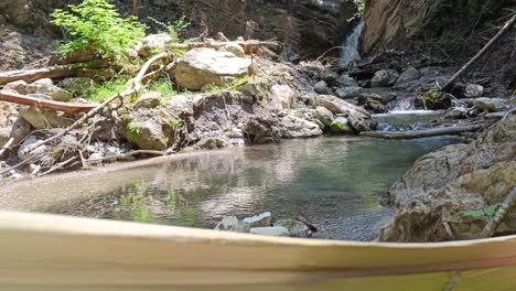 POV-view-from-guy-laying-in-hammock-next-to-beautiful-river-and-waterfall