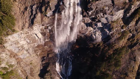 Aerial-drone-footage-pushing-out-with-top-down-views-of-a-picturesque-waterfall-in-Grindelwald-in-the-Swiss-Alps