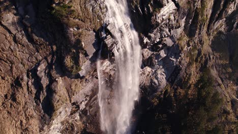 Aerial-drone-footage-raising-up-and-turning-left-with-stunning-views-of-Fallbach,-a-waterfall-in-Grindelwald-in-Switzerland