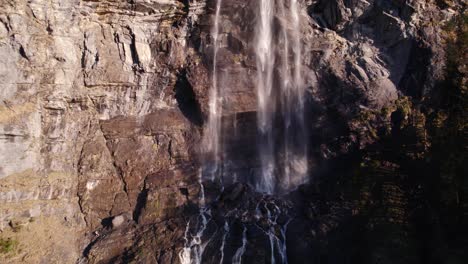Aerial-drone-footage-pushing-in-at-the-bottom-of-a-spectacular-waterfall-in-Grindelwald-in-the-Swiss-Alps