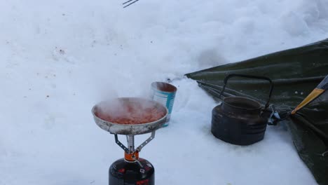 Frijoles-Horneados-Cocinados-Y-Revueltos-En-Una-Cocina-De-Gas-En-La-Nieve-Mientras-Acampa