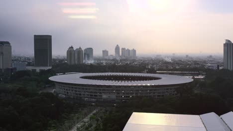 Aerial-light-flare-of-sun-setting-over-GBK-Sports-Complex-and-Stadium-over-Jakarta-skyline
