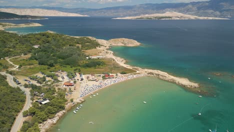 Aerial-view-of-Croatian-coastline-with-scenic-wilderness-coastline-and-priest-sea-water-with-sail-boat-ant-luxury-yacht-moored-in-travel-holiday-summer-destination-in-europe