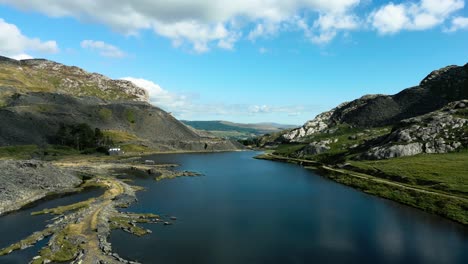Wunderschöner-Luftblick-über-Einen-See,-Der-Auf-Die-Majestätischen-Berge-Von-Wales-Trifft
