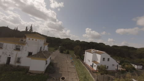FPV-flight-over-small-arid-orchard-grove-to-old-Spanish-farm-house