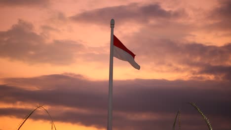 Indonesische-Flagge,-Die-Auf-Einem-Hohen-Mast-Gegen-Einen-Dramatischen-Abendhimmel-Weht