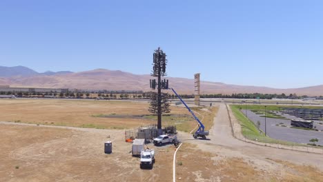 Minigrúa-Montada-En-Una-Torre-De-Telecomunicaciones-Durante-La-Reparación-Cerca-De-Puntos-De-Venta-En-Tejon-En-California,-Estados-Unidos