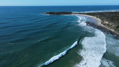 Revealing-drone-view-of-larges-waves-breaking-on-a-rugged-coastal-beach