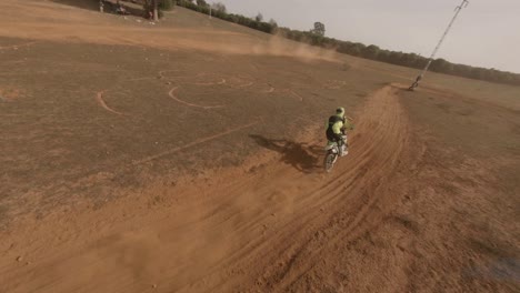 Fast-FPV-drone-catches-up-to-motorcycle-moto-racer-on-sandy-dirt-track