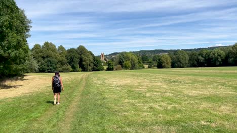 Sportive-girl-walking-the-Cotswolds-Way,-a-long-distance-footpath-in-England