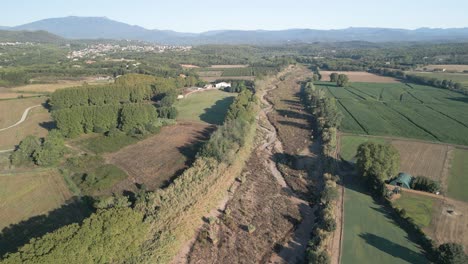 Aerial-images-over-a-dry-river-next-to-crops-in-spain-catalunya