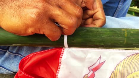 A-man's-hand-is-tying-a-flag-string-on-a-bamboo-stick