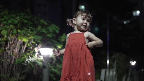 Süßes-2-jähriges-Mädchen,-Das-Nachts-Im-Park-Steht-Und-Posiert---Breit