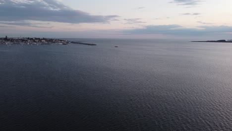 Fishing-motorboat-entering-Punta-del-Este-harbor,-aerial-forward-drone-pov