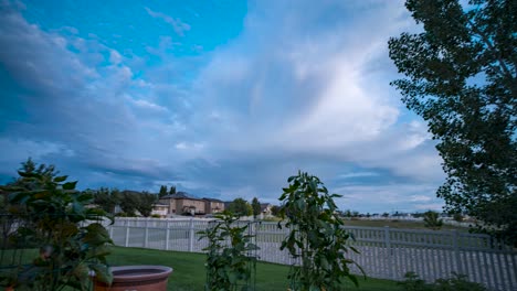 A-backyard-garden-at-dusk-with-a-dynamic-cloudscape-overhead---tilt-up-panning-motion-time-lapse