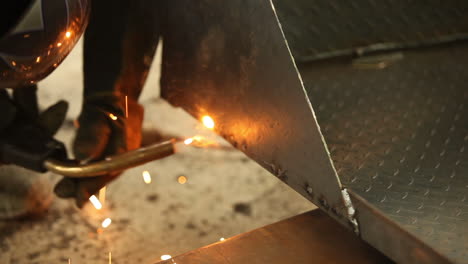 Welder-and-his-arc-connecting-metal-sheets-together-and-checking-the-work-as-he-goes-for-any-imperfections