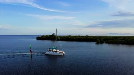 Catamaran-driving-on-the-coast-south-Florida,-during-sunset---orbit,-Aerial-view