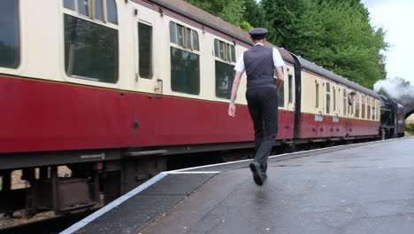 Steam-train-locomotive-railway-conductor-walking-along-the-platform-at-the-station