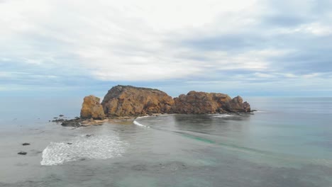 Aerial-orbit-around-a-coastal-rock-formation-in-southern-Australia-in-calm-seas