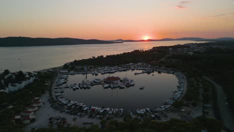 Aerial-view-of-solaris-coastline-croatia-town-on-Adriatic-Sea,-luxury-sail-boat-moored-in-port-harbour-at-sunset,-drone-reveal-stunning-seascape