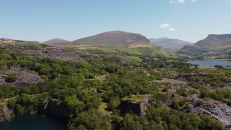 Dorothea-disused-overgrown-slate-mining-quarry-in-lush-dense-magical-Snowdonia-mountain-woodland-aerial-view