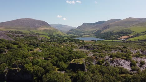 Dorothea-disused-overgrown-slate-mining-quarry-in-lush-dense-Snowdonia-mountain-woodland-landscape-aerial-view