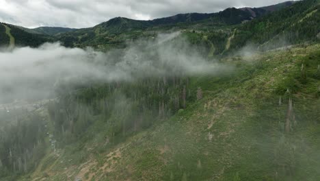 Aerial-of-low-fog-hanging-over-mountain-and-forest-trees-4