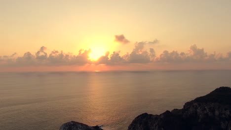 Orange-Sonnenuntergang-Hinter-Wolken-über-Ruhigem-Meer-Am-Strand-Von-Maruata,-Michoacan,-Mexiko