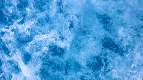 Hectic,-chaotic-whitewash-ocean-wake-and-spray-from-a-fast-moving-motorboat,-closeup-of-sea-and-fast-flowing-swirling-water