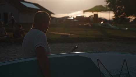 Silhouette-Eines-Mannes,-Der-Während-Des-Sonnenuntergangs-Paddleboard-Gegen-Die-Sonne-Hält,-Schöne-Filmische-Nahaufnahme