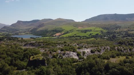 Dorothea-disused-overgrown-slate-mining-quarry-in-lush-dense-Snowdonia-mountain-woodland-valley-aerial-view