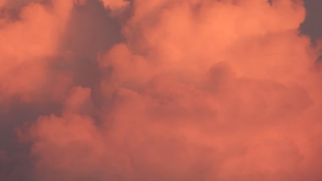 Close-up-time-lapse-shot-of-soft-and-fluffy-coral-color-clouds-movements-with-dreamy-summer-vibe-at-sunset-golden-hours