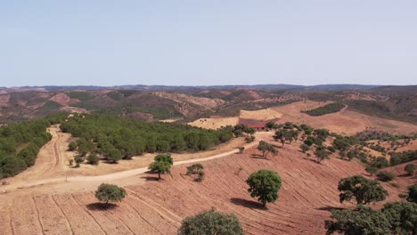 Fliegen-In-Richtung-Bauernhaus-Auf-Einem-Hügel-Mit-Bergkette-Im-Hintergrund-Im-Alentejo,-Portugal