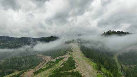 Aerial-of-low-fog-hanging-over-mountain-and-forest-trees-11