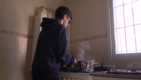 Retrato-De-Un-Joven-En-La-Casa-Ocupado-Cocinando-Comida-En-La-Cocina