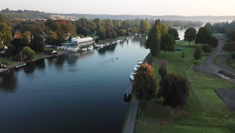 Peaceful-sunrise-drone-shot-of-a-single-rower-on-the-river-in-Henley-on-Thames,-Oxfordshire