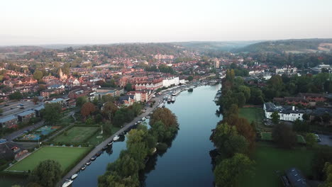 Beautiful-morning-drone-shot-of-Henley-on-Thames,-panning-high-above-the-river-and-moving-towards-the-town-from-the-West