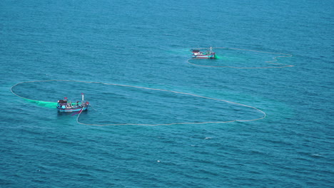 Aerial-static-shot-of-boats-in-blue-sea-doing-net-fishing