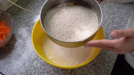 Baker's-Hands-Sifting-Wholemeal-Flour-With-Sieve-In-The-Kitchen