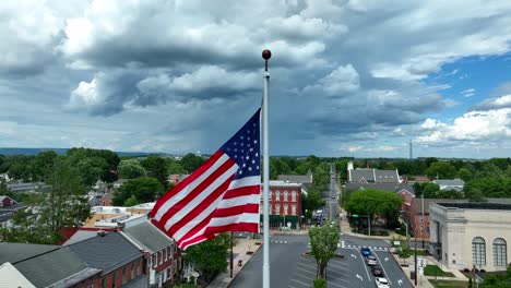 Thunderstorm-clouds-in-sky-with-American-flag-waving-in-breeze
