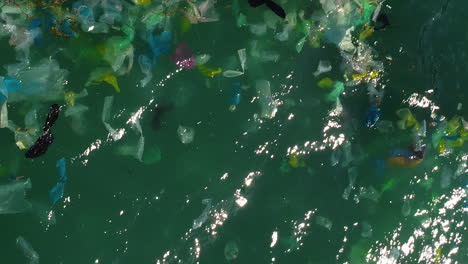 Floating-plastic-rubbish-on-blue-tropical-ocean,-top-down-view