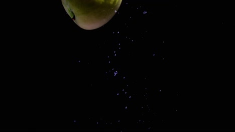 Apple-diet-concept,-Cinematic-shot-of-green-apple-falling-into-the-water,-background-of-a-single-fruit-inside-water