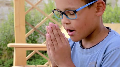 Little-boy-praying-to-God-with-hands-together-stock-footage