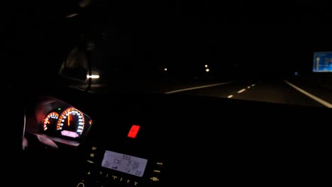 Dashboard-of-modern-car-driving-at-night-on-double-land-highway