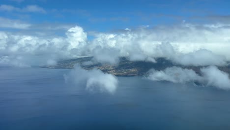 Vista-Aérea-De-La-Isla-De-Madeira-Y-El-Aeropuerto-De-Funchal,-Tomada-A-1000-M-De-Altura-Desde-Una-Cabina-De-Jet-Durante-La-Aproximación,-En-Un-Hermoso-Día-De-Verano-Con-Algunas-Nubes-Sobre-Las-Montañas